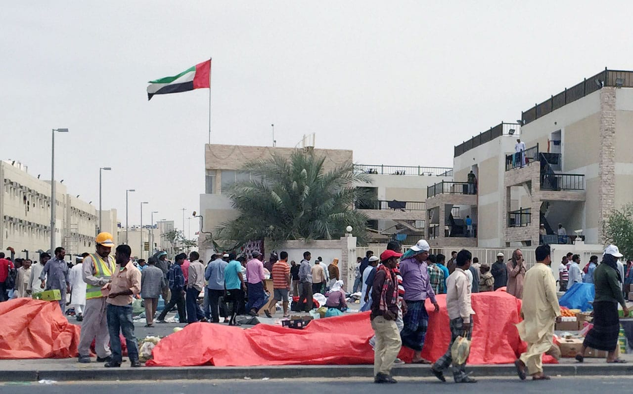 Migrant workers outside a workers' camp in Mafraq, Abu Dhabi. (photo by the author for Hyperallergic)