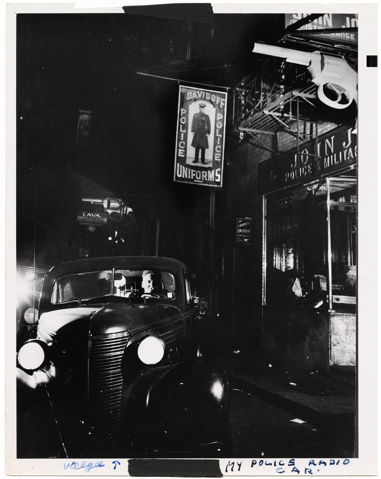 Weegee in his car in front of the police supply shops at 5 & 6 Centre Market Place (1942). The photographer's studio was above one of the stores. (all photographs courtesy Prestel)