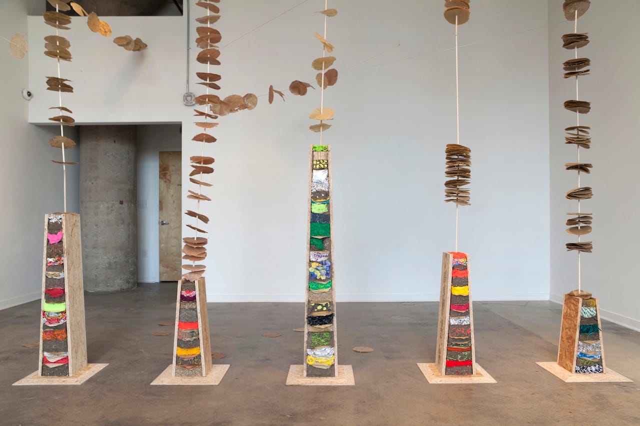 Megan Heeres' manufactured 'trees' bearing bio-leaves of different invasive species papers. Photo by Eric Wheeler.