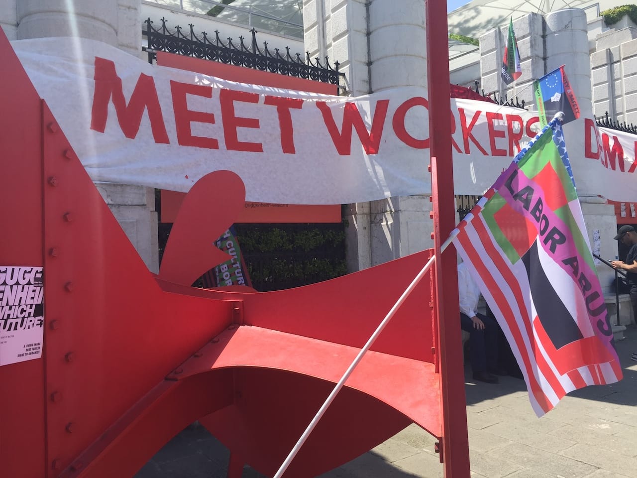 Flyers, flags, and banners outside the Peggy Guggenheim Collection and propped against an Alexander Calder sculpture