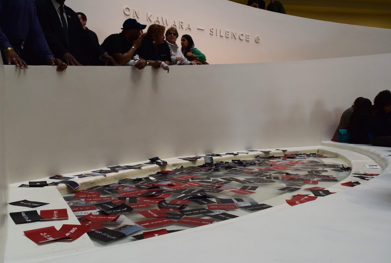 Protesters' On Kawara-inspired leaflets filling the Guggenheim Museum fountain.