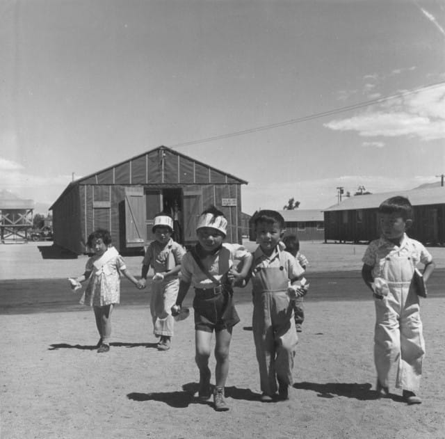 Manzanar, CA, July 1, 1942. Preschoolers on the way to their barrack homes from morning class at the camp 220 miles north of L.A. The camp was later made famous by books like Jeanne Wakatsuki Houston’s 1973 Farewell to Manzanar (Photographed by Dorothea Lange, WRA / Courtesy of the National Archives via the National Park Service)