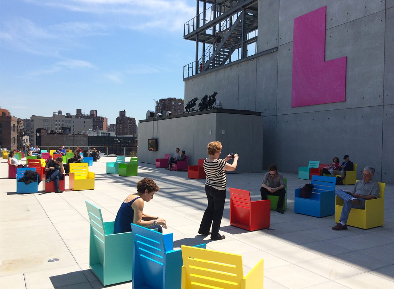 An outdoor terrace on the new Whitney Museum's fifth floor with chairs and a wall sculpture by Mary Heilmann