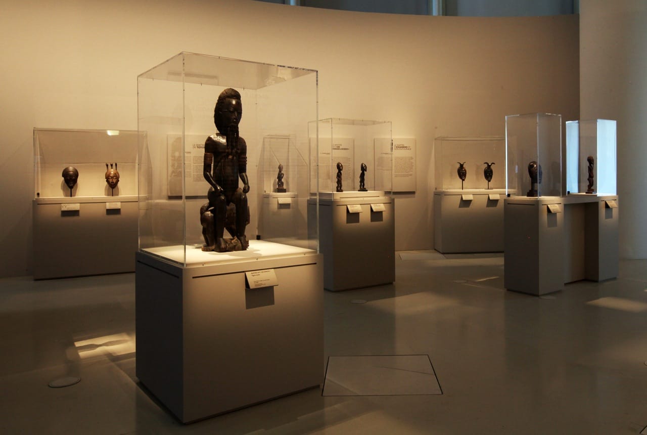 MusÈe du quai Branly. Affiche de l'exposition "Les maÓtres de la sculpture de CÙte d'Ivoire". Du 14 avril au 26 juillet 2015. Galerie Jardin. Vue de l'exposition. RÈunissant prËs de 200 oeuvres historiques et contemporaines, l'exposition met ‡ l'honneur les grands sculpteurs et les Ècoles de sculpture de CÙte d'Ivoire et de ses pays limitrophes. Elle resitue les sculptures dans le contexte religieux et stylistique des Ateliers du 19e et dÈbut du 20e siËcle, notamment chez les SÈnoufo, les Lobi, les Dan ou encore les BaoulÈ, en les considÈrant sous l'angle de leur force esthÈtique et de la singularitÈ de leur crÈateur. L'exposition prÈsente Ègalement des installations et oeuvres d'artistes contemporains: la nouvelle gÈnÈration d'artistes africains ´ transnationaux ª, hÈritiËre des grands artistes du passÈ, met en avant la continuitÈ crÈative des sculpteurs d'Afrique de l'Ouest dans la pÈriode postcoloniale.