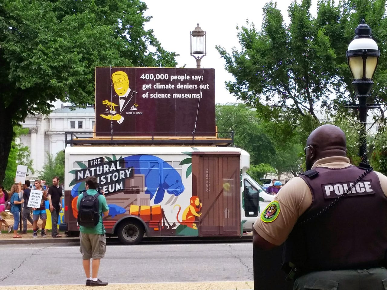 A police officer watches the demonstration from across the street.
