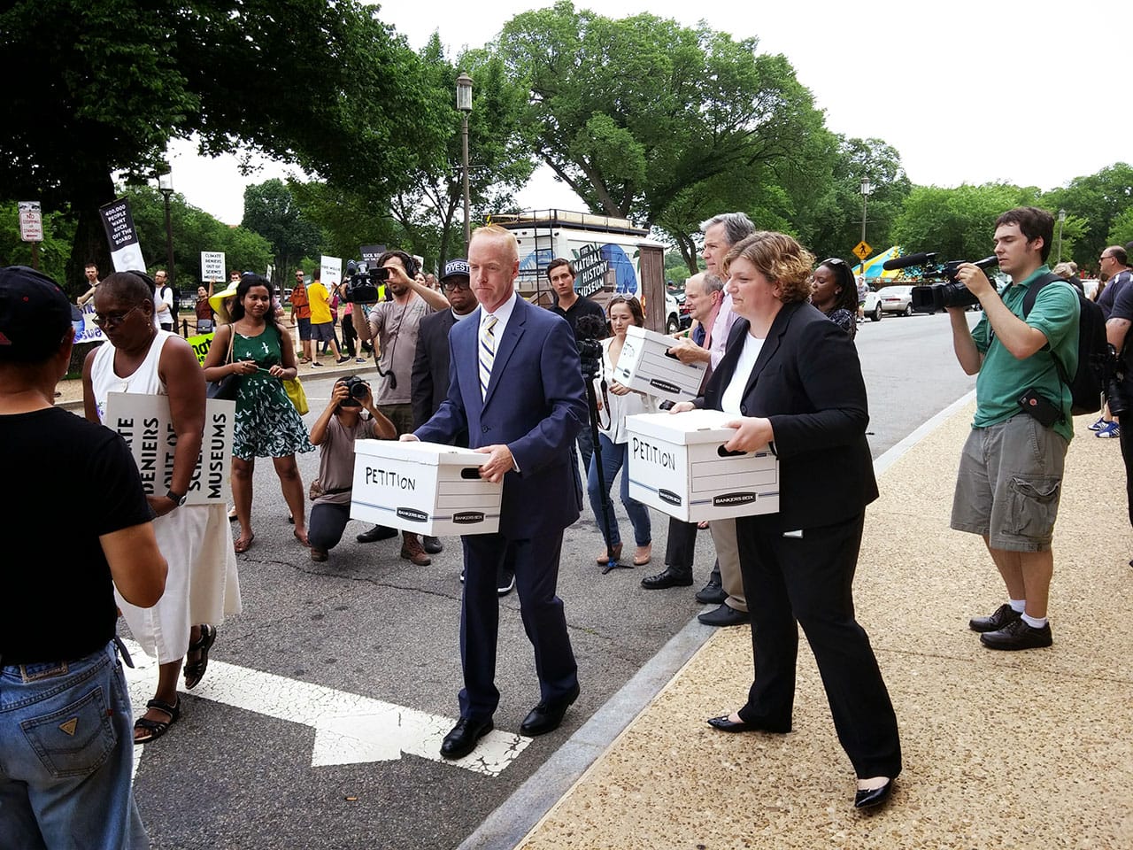Protestors hand Smithsonian representatives boxes containing nearly 430,000 signatures in support of the anti-Koch cause. (all photos by Ryan Little for Hyperallergic)