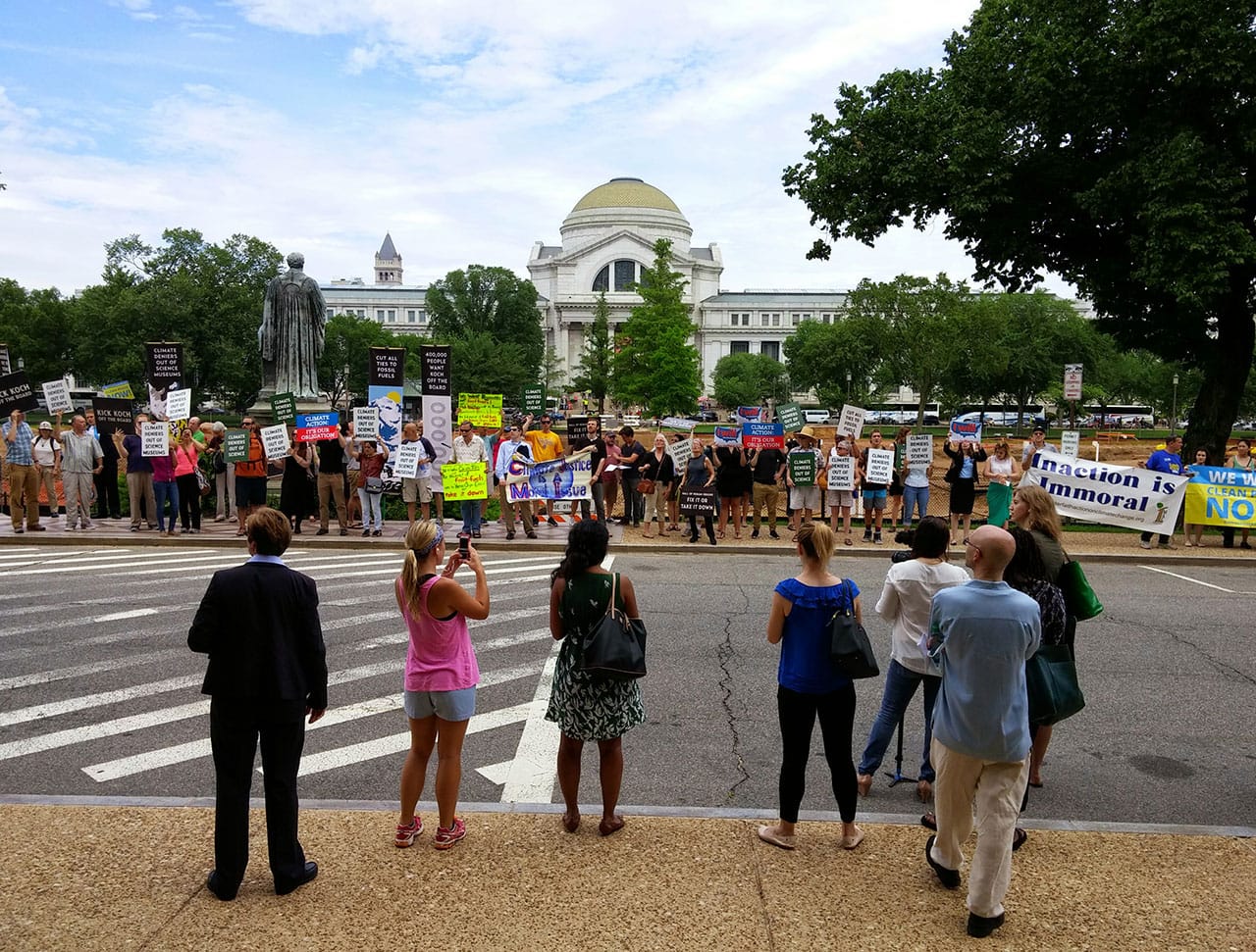 Spectators survey the protesters in front of the Smithsonian castle.