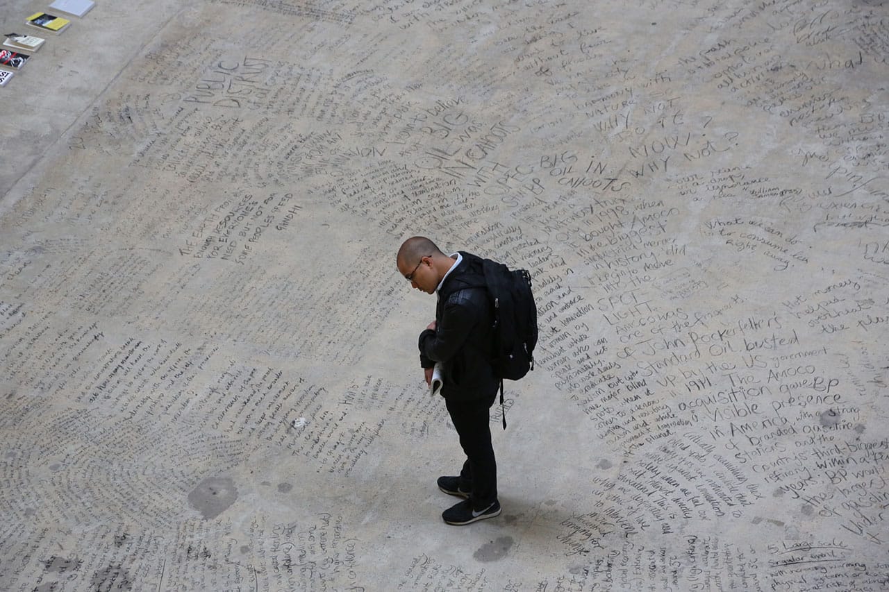 A museum visitor reading the words left by members of Liberate Tate during the 25-hour "Time Piece" performance.