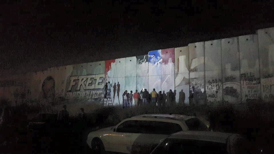 Photo of the West Bank wall being whitewashed on the evening on Monday, June 29. (via Fadi Arouri's Facebook page)
