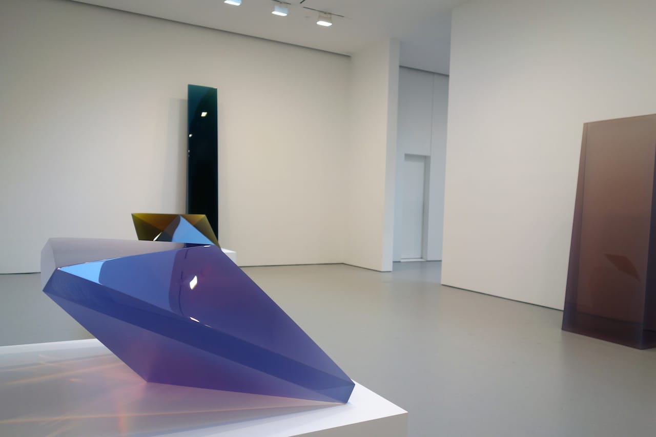 Installation view of 'De Wain Valentine: Works from the 1960s and 1970s,' with "Double Pyramid Rose-Violet" (1968), cast polyester resin, at foreground