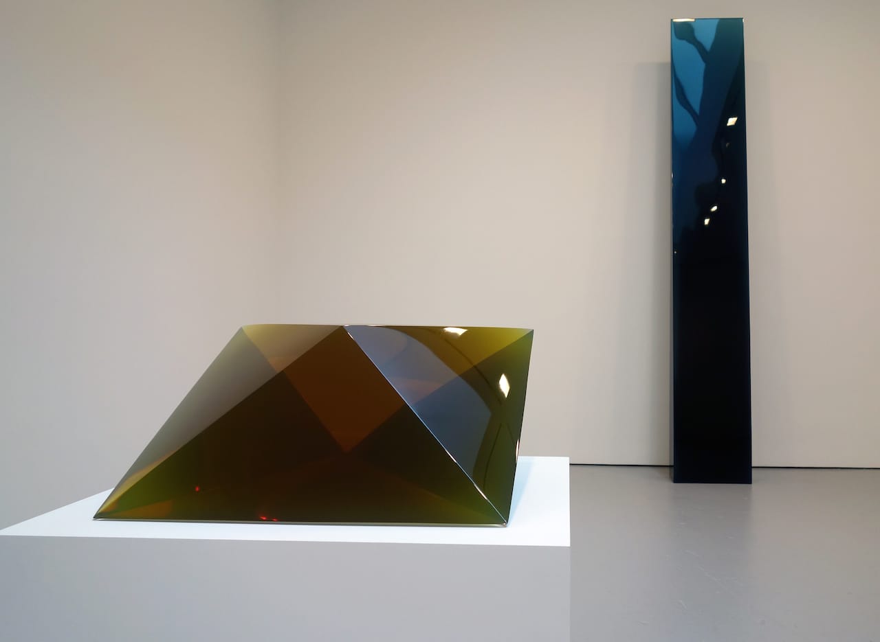 At left: De Wain Valentine, "Double Pyramid Fluorescent Green" (1970), cast polyester resin, 13 3/4 x 29 1/2 x 25 7/8 inches