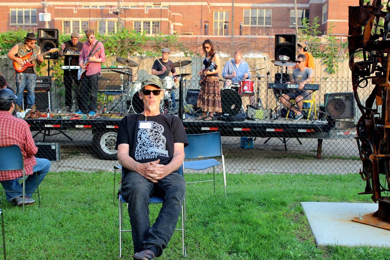 Robert Sestok, sitting in front of the Recycle Here jam band, which assembled to play the opening.