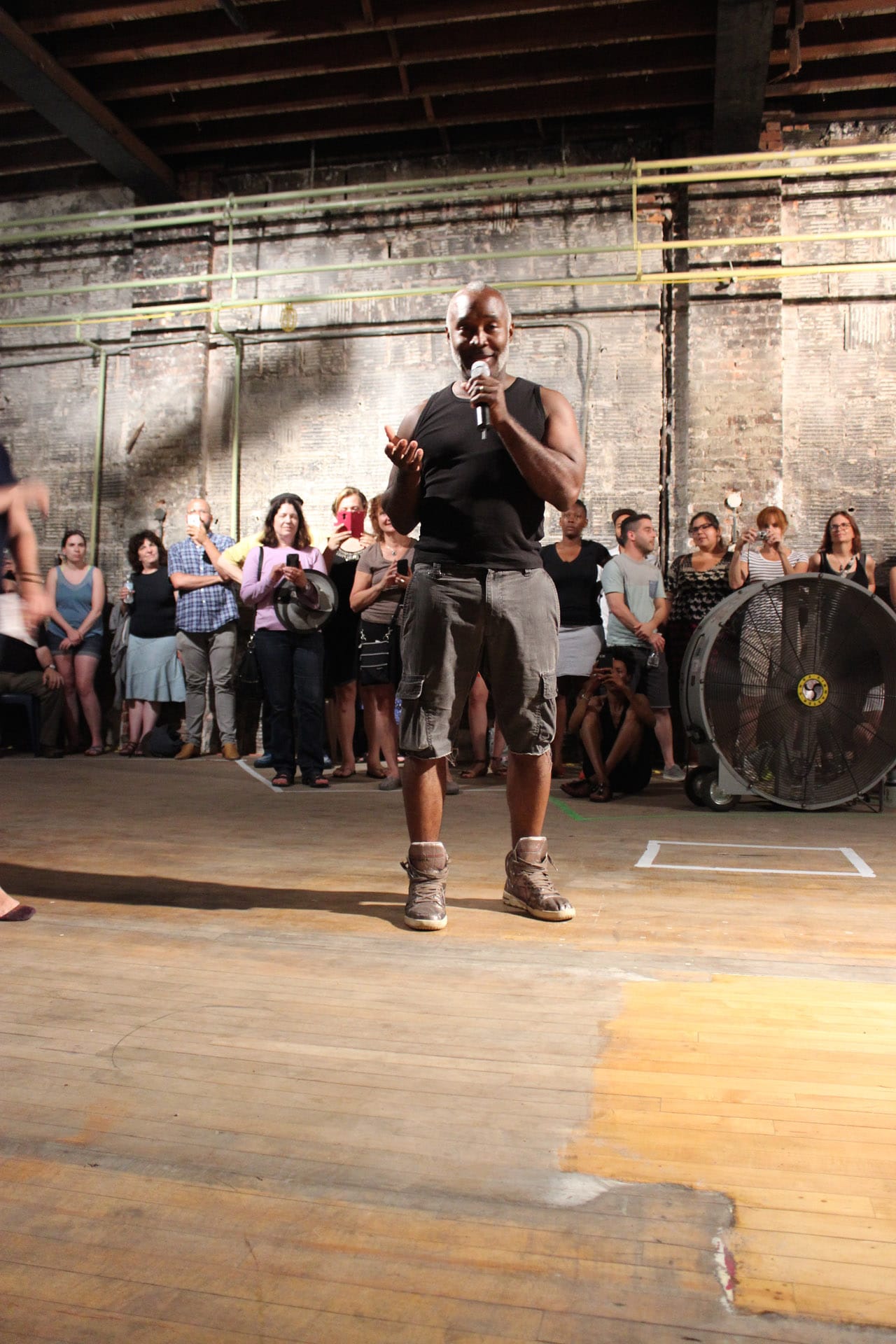 Cave speaks to the crowd of hundreds, packed into the Ruth Ellis Center performance space.