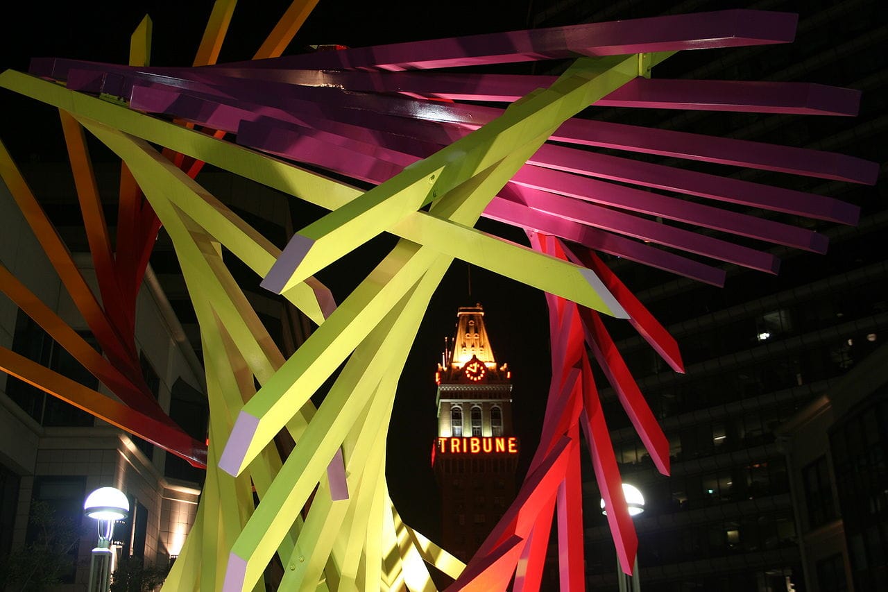 The Oakland Tribune Building, as seen through a sculpture in the City Center complex. (sculpture © David Corby, photo © Roslyn Mazzilli, via Wikimedia Commons)