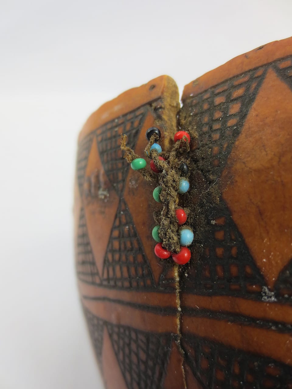 Gourd  from South Sudan with a stitched plant fiber repair incorporating glass beads (1979) (courtesy Pitt Rivers Museum, University of Oxford)