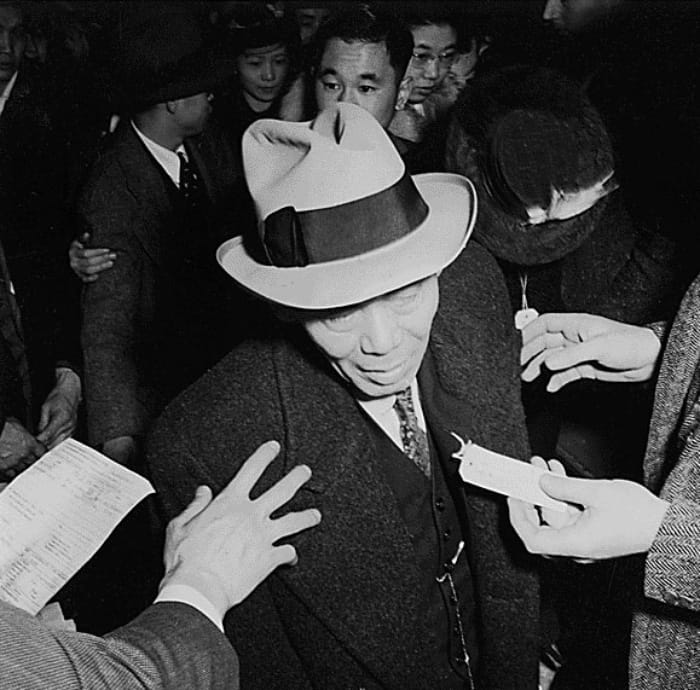 A man about to step onto the bus for Santa Anita temporary detention center. A government committee report from the same year describes the man in the image as “labeled, checked against the master list” and “ready to leave” (photographed by Dorothea Lange, WRA, courtesy the National Archives)