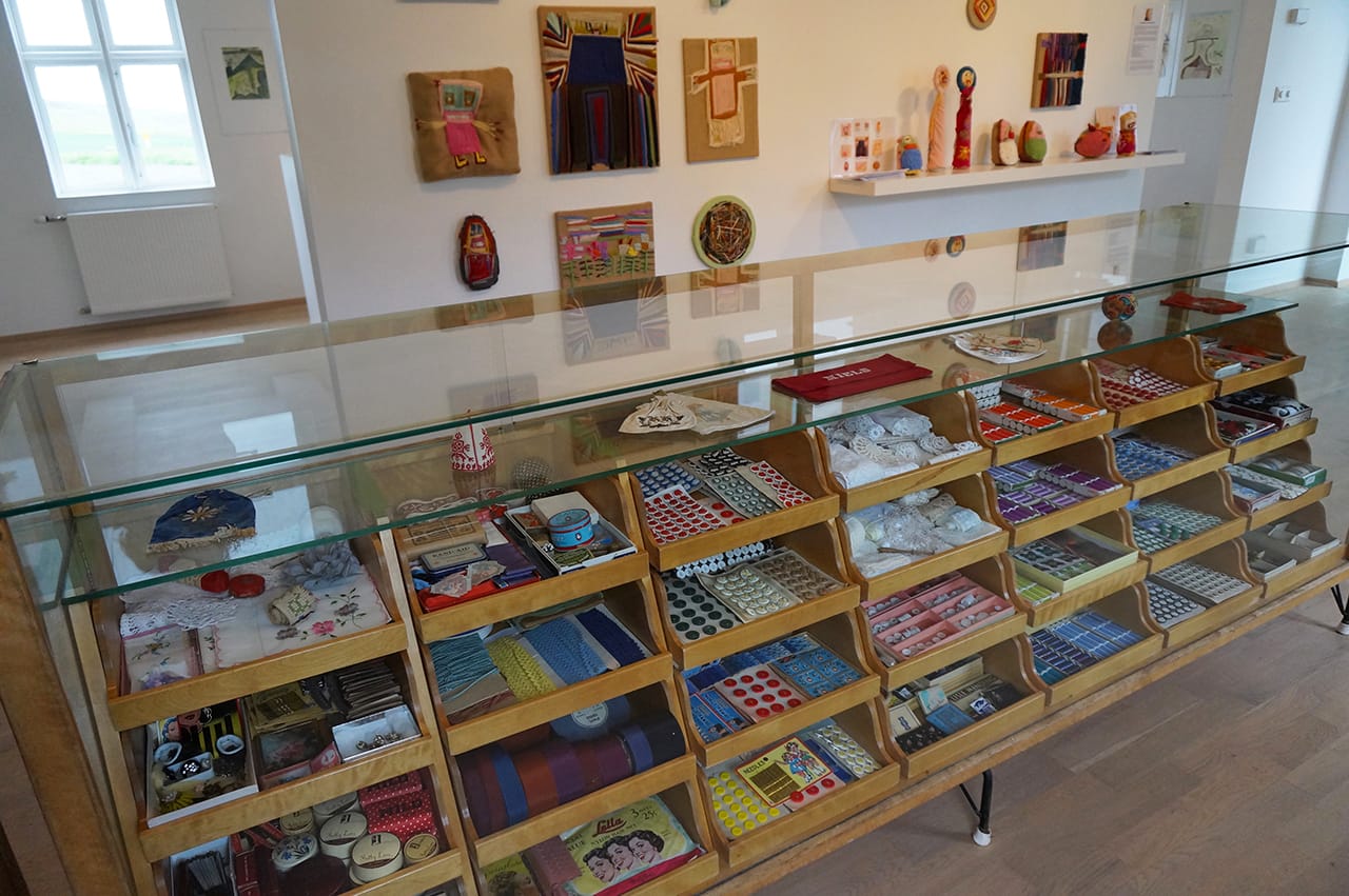 Embroidery display with works by Erla Björk Sigmundsdóttir in the background