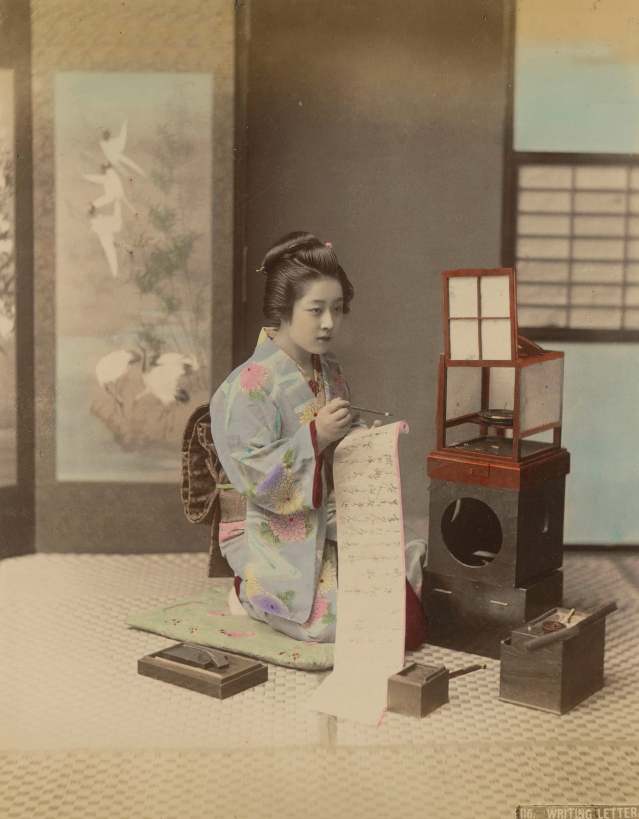Kusakabe Kimbei: Geisha, penning a letter, around 1885. albumin paper colored, 26,1 x 20,6 cm. © National Museums in Berlin, art library. 