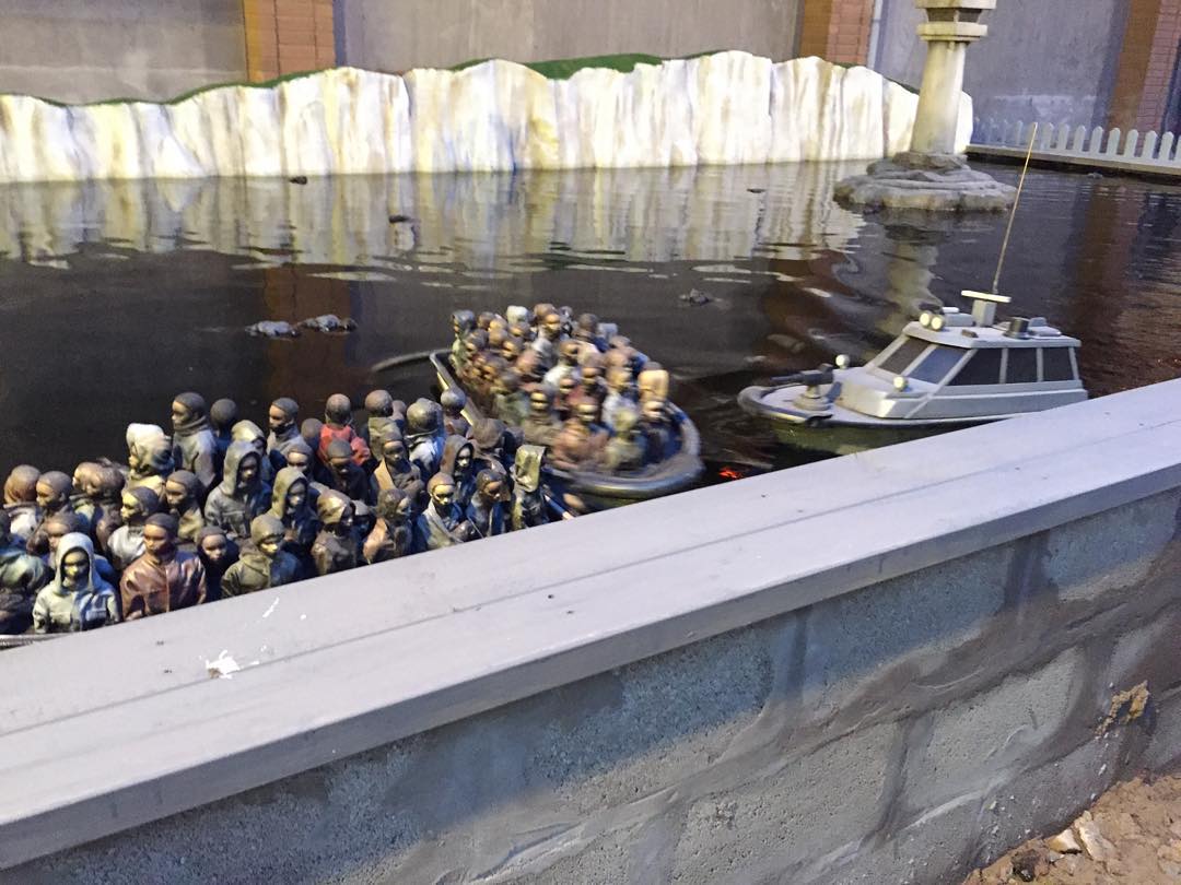 RC boats by Banksy, with the police boat ramming the boats full of migrants.