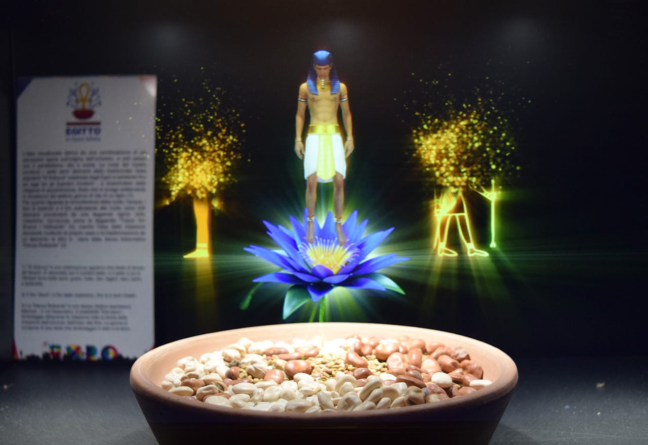 A hologram of a shirtless pharaoh dancing over a plate of beans and cereals in the Egyptian pavilion