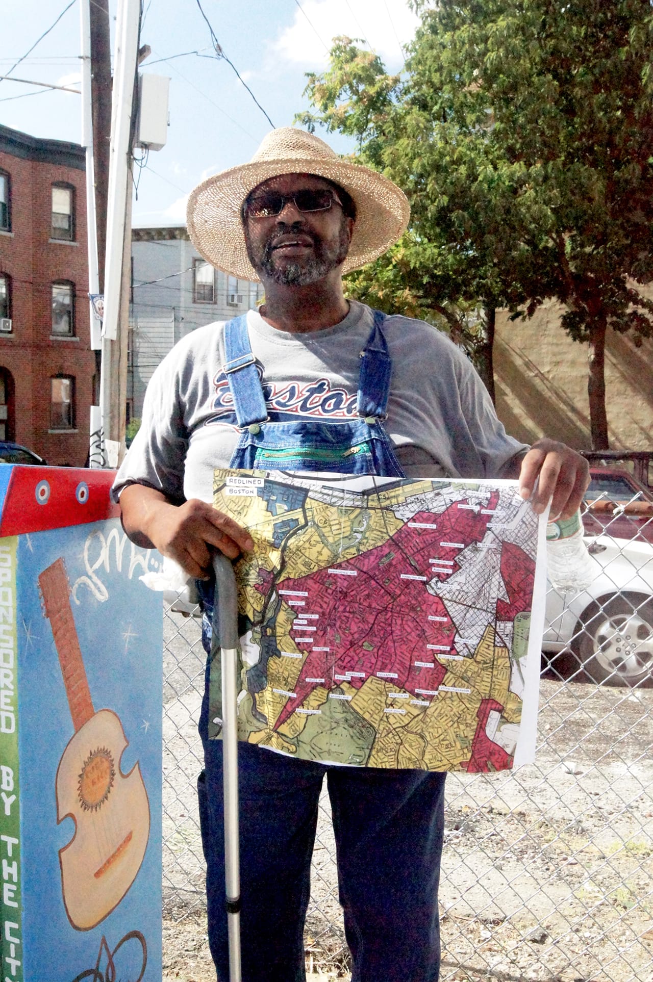 Lonnie Hutton holds up the historic FHA redlining map of the neighborhood.