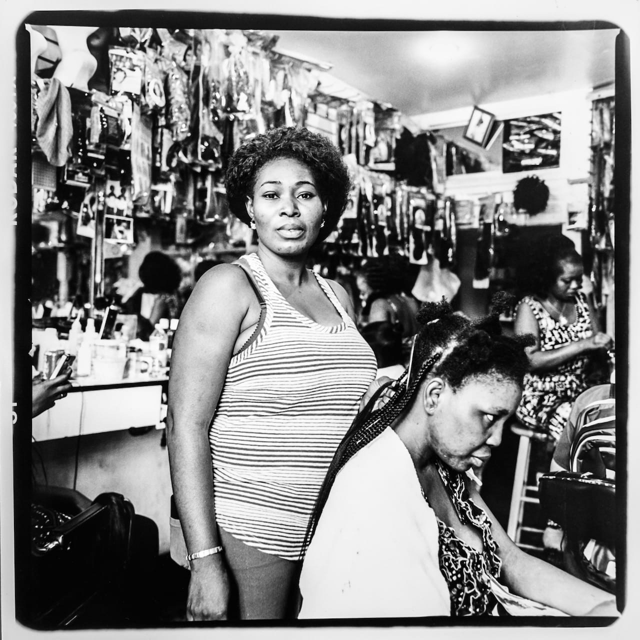 Rebecca, originally from Ghana, works part-time at the GOD IS WONDERFUL Hair Weave & Braiding Center at Jerome and 183rd street which her sister Beatrice has owned for over ten years. Rebecca has been married for two years: she and her husband are both studying health care and she aspires to be a doctor. Photo taken August 2015 by Adi Talwar/Bronx Photo League.