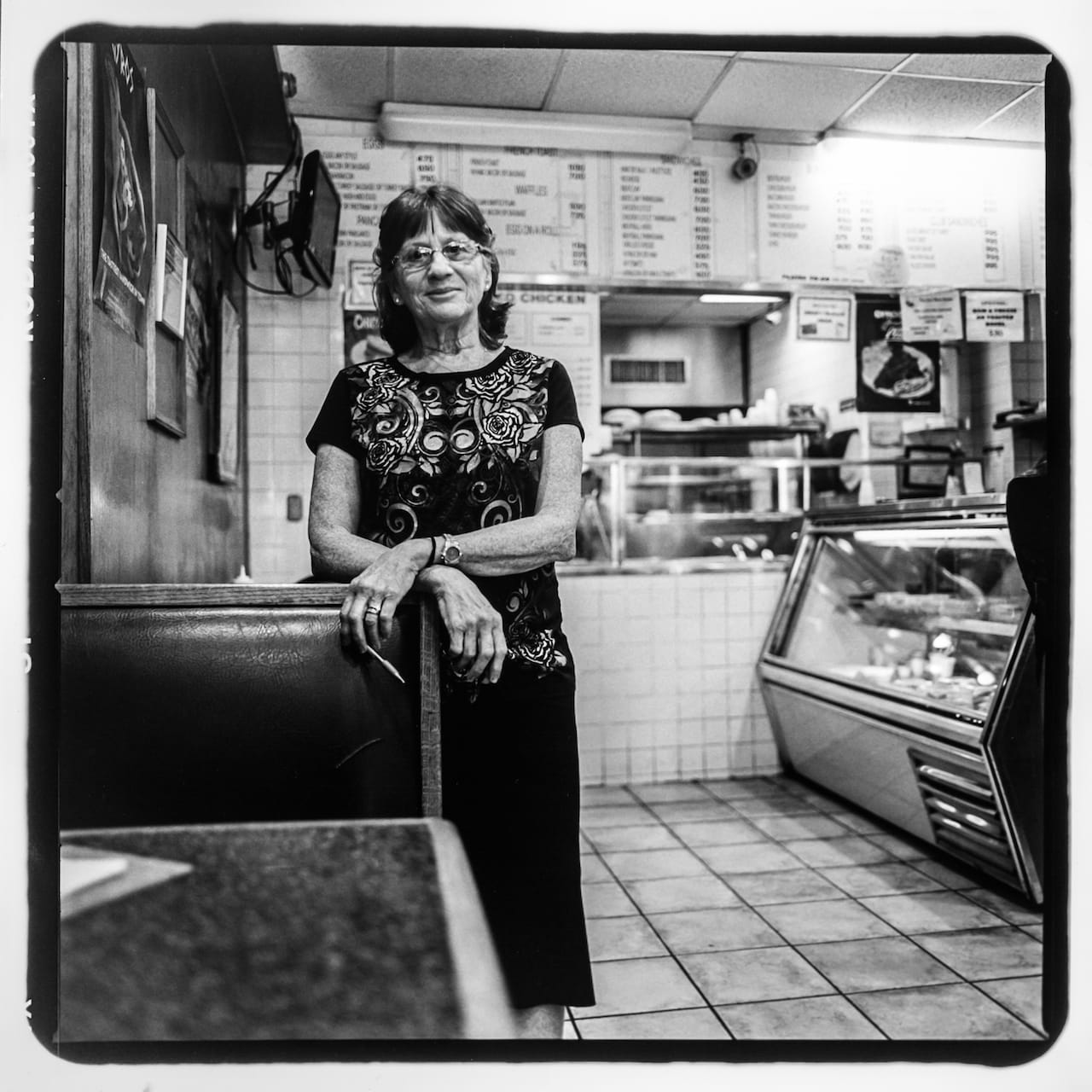 Tessie Polygerinos at Munchtime Diner on 170th St. between Jerome Ave; Townsend Ave. Her husband, Laki, has owned the diner since the 1960s. The diner has been serving Bronx residents for over 60 years. Photo taken August 2015 by Trevon Blondet/Bronx Photo League.