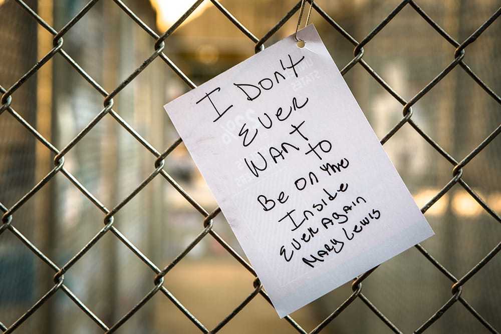 A paper affixed to the chain-link fence of "Labyrinth" (2015)