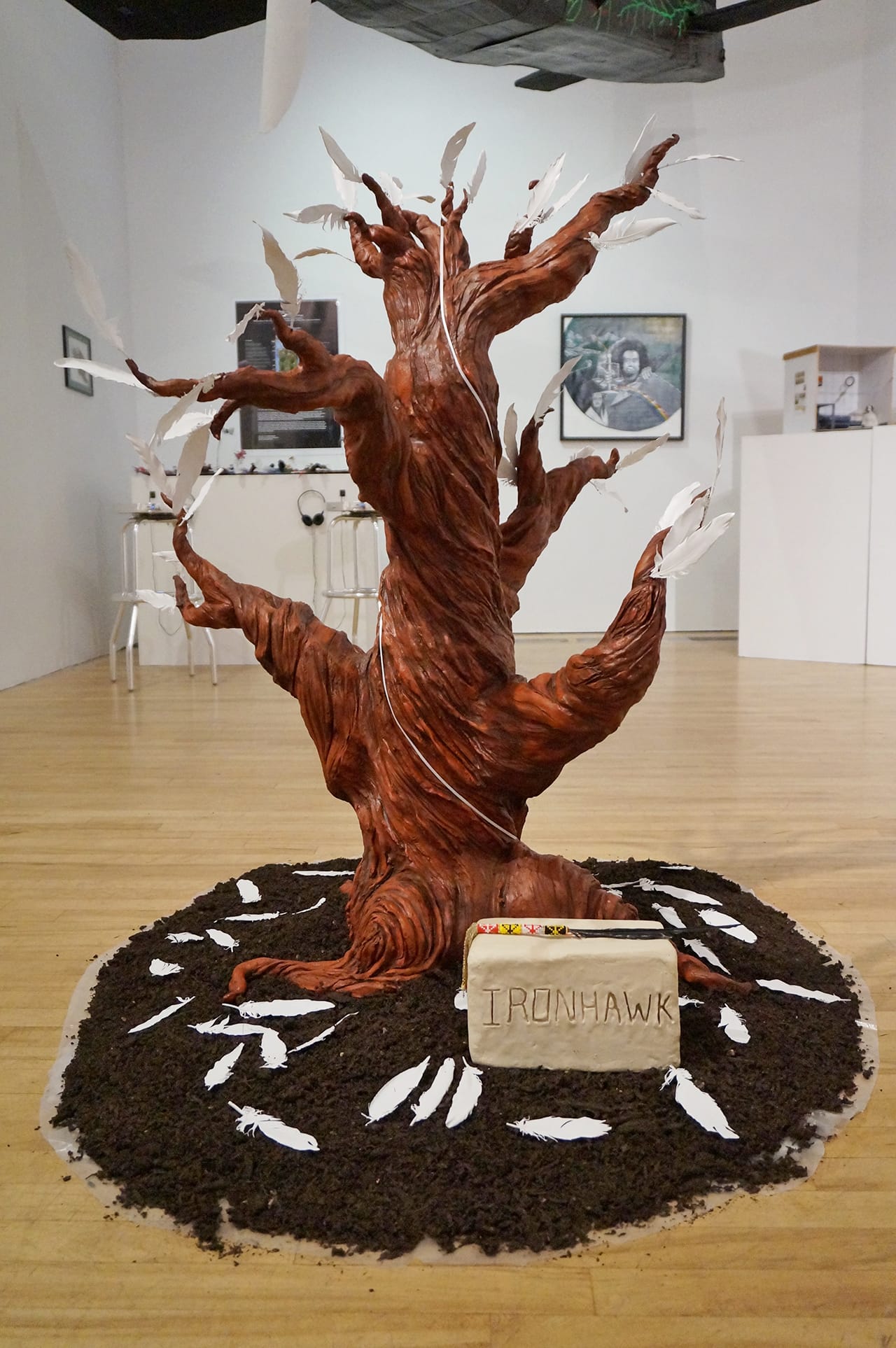 Declicho Besh, aka "Ironhawk," in collaboration with Sophia Stevenson, "Tree" (2015), clay and painted feathers, dims variable