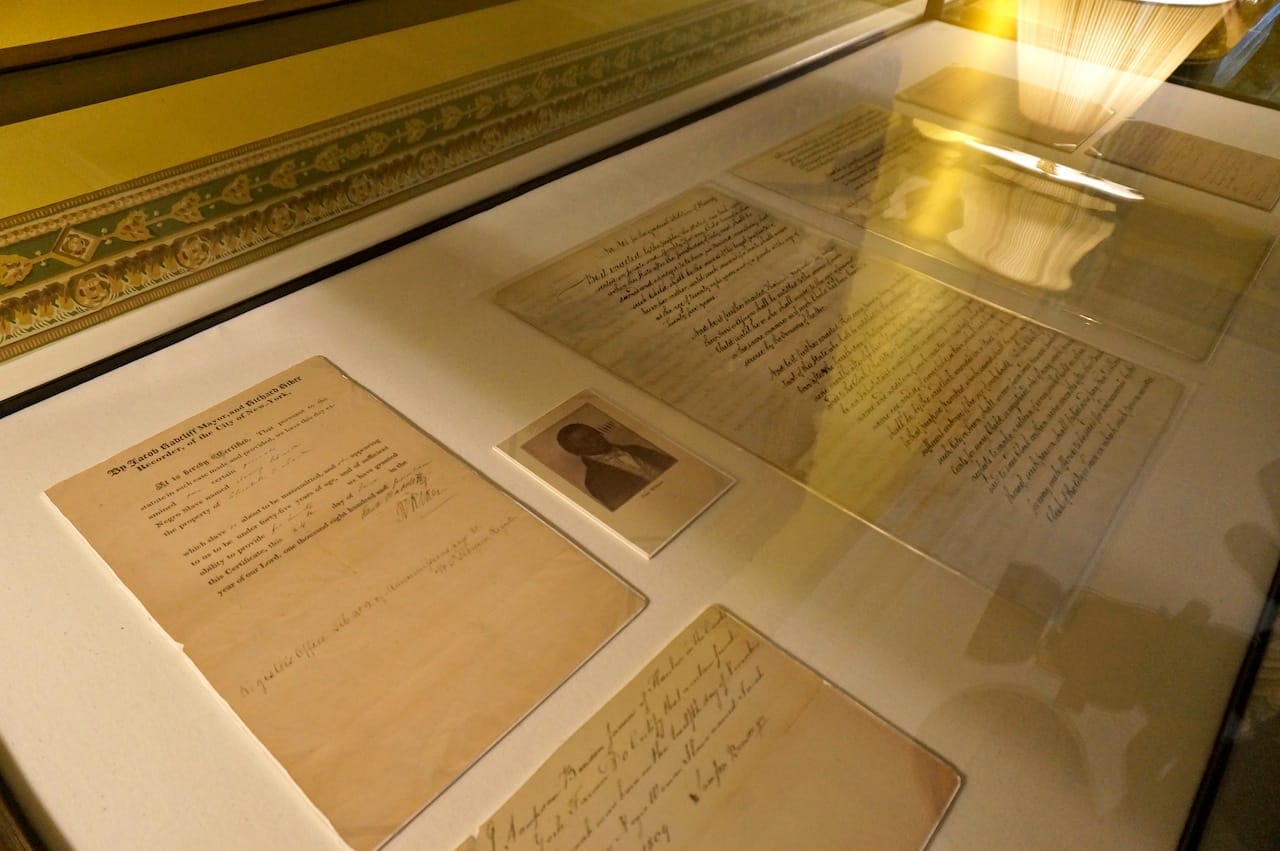 A slave bill of sale and the New York State Gradual Emancipation Act of 1799 in a display case at Gracie Mansion (click to enlarge)