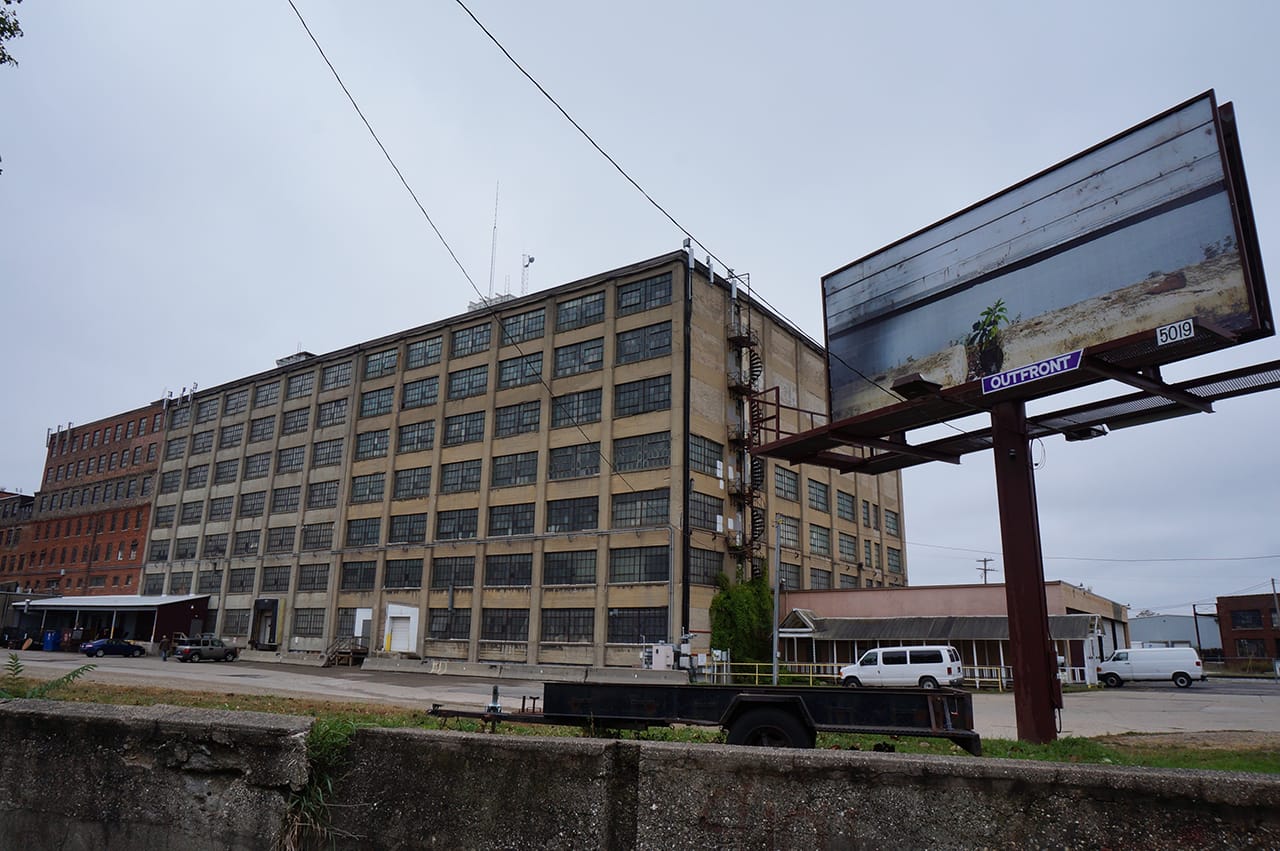 A factory in Grand Rapids, with a billboard by artist Lynn Cazabon at right
