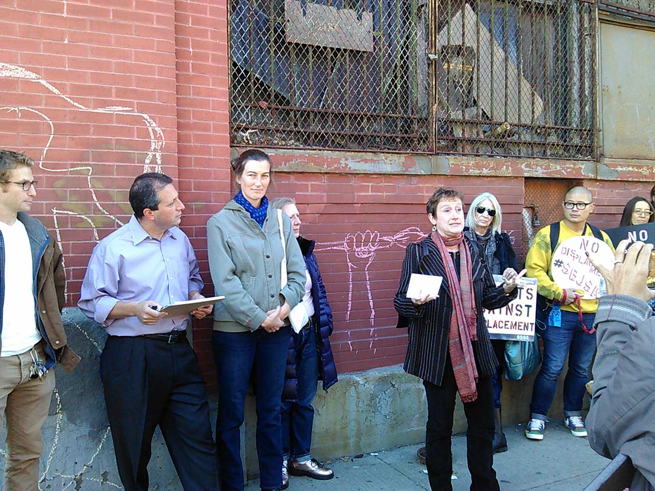 Jenny Dubnau (ASAP) speaking at the rally, and to her right is Abby Subak (executive director of Arts Gowanus), who is standing next to Council Member Brad Lander. 