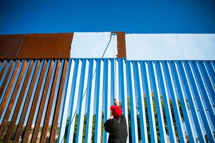 A volunteer helps paint the border fence in Nogales, Mexico.