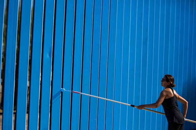 Artist Ana Teresa Fernández paints a section of the border fence along Nogales, Mexico (all images courtesy of Deanna Dent, Arizona State University)