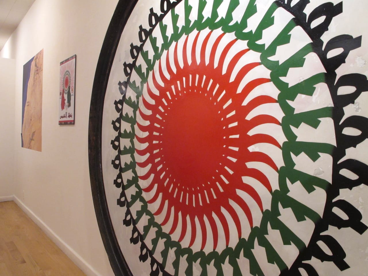 A close up of the repurposed Texaco sign, now featuring the logo for "The Potential Project," a repetition of the Saharawi word for "freedom"