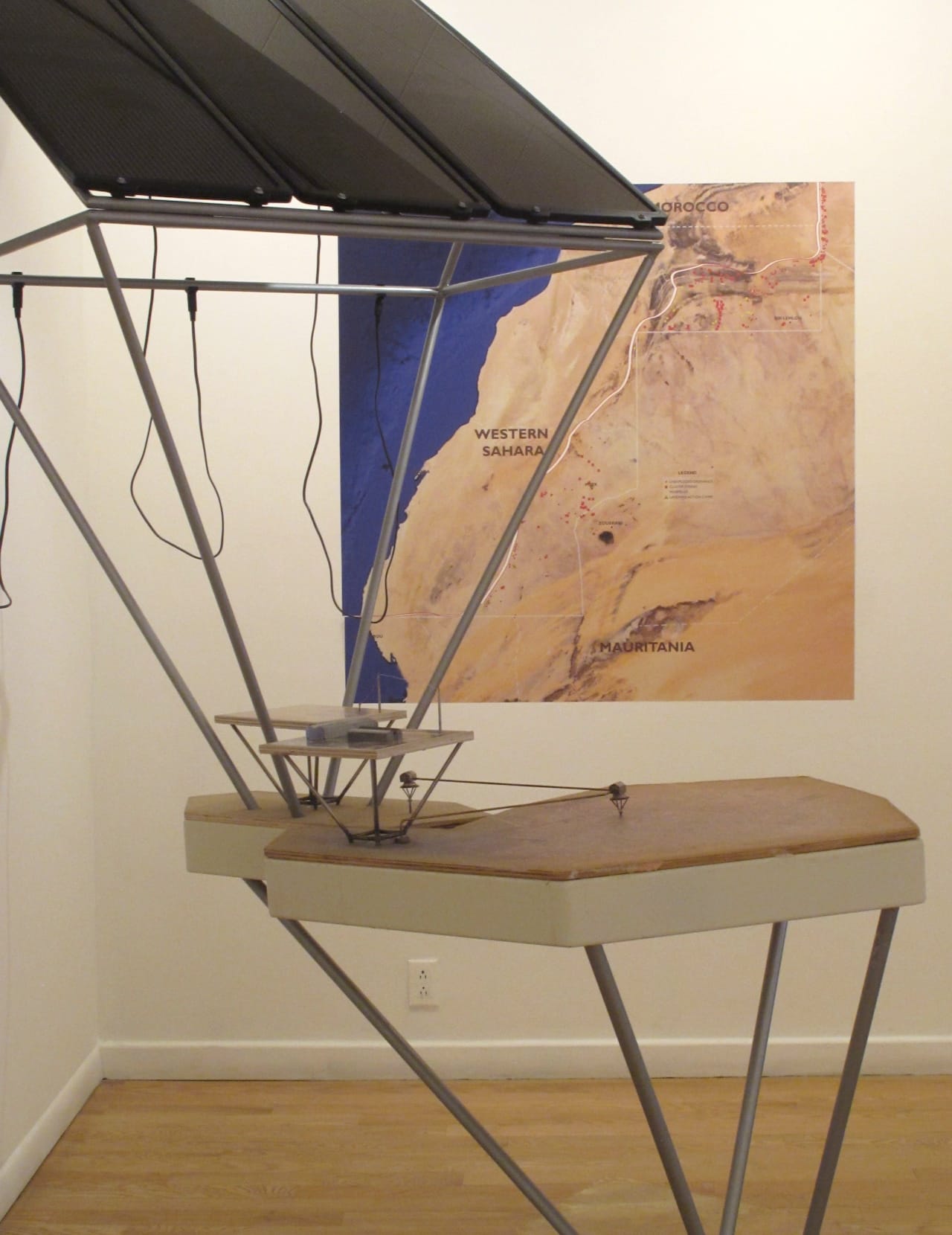 A model of "The Bank of the Sun" in front of a map of Western Sahara