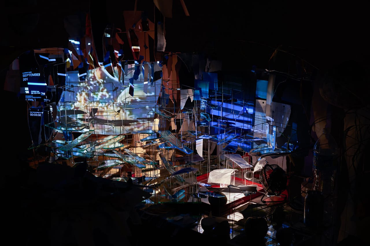 Sarah Sze, "Measuring Stick" (detail) (2015), video projectors, fan, light, mirrors, wood, stone, archival prints, speakers, stainless steel, balloon, sand, fruit, egg, plastic, toilet paper, aluminum foil, grass, 132 x 90 x 51 in (335.3 x 228.6 x 129.5 cm) (photo by Mike Barnett)
