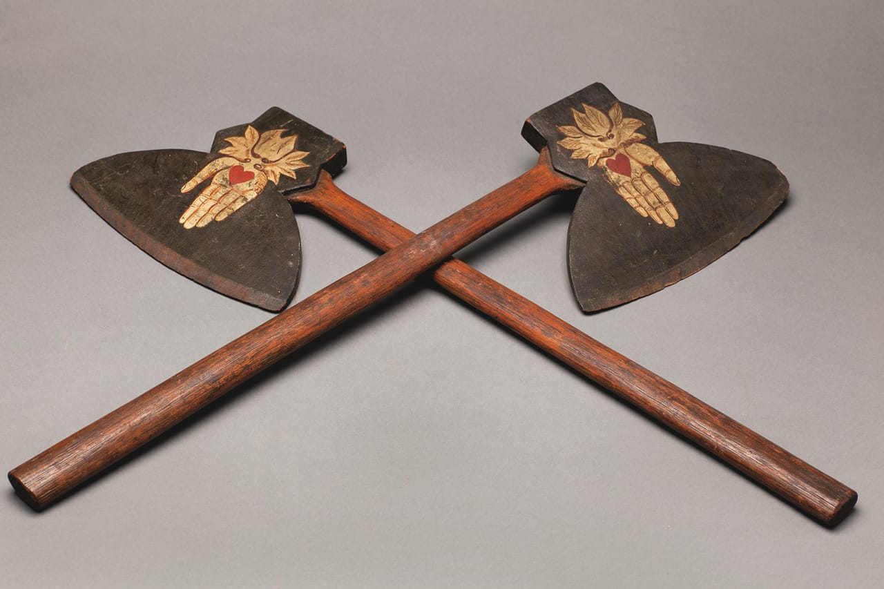 Pair of Odd Fellows axes (1870s), unidentified artist, carved wood with painted heart in hand decoration, each 28 × 8 × 1 in.