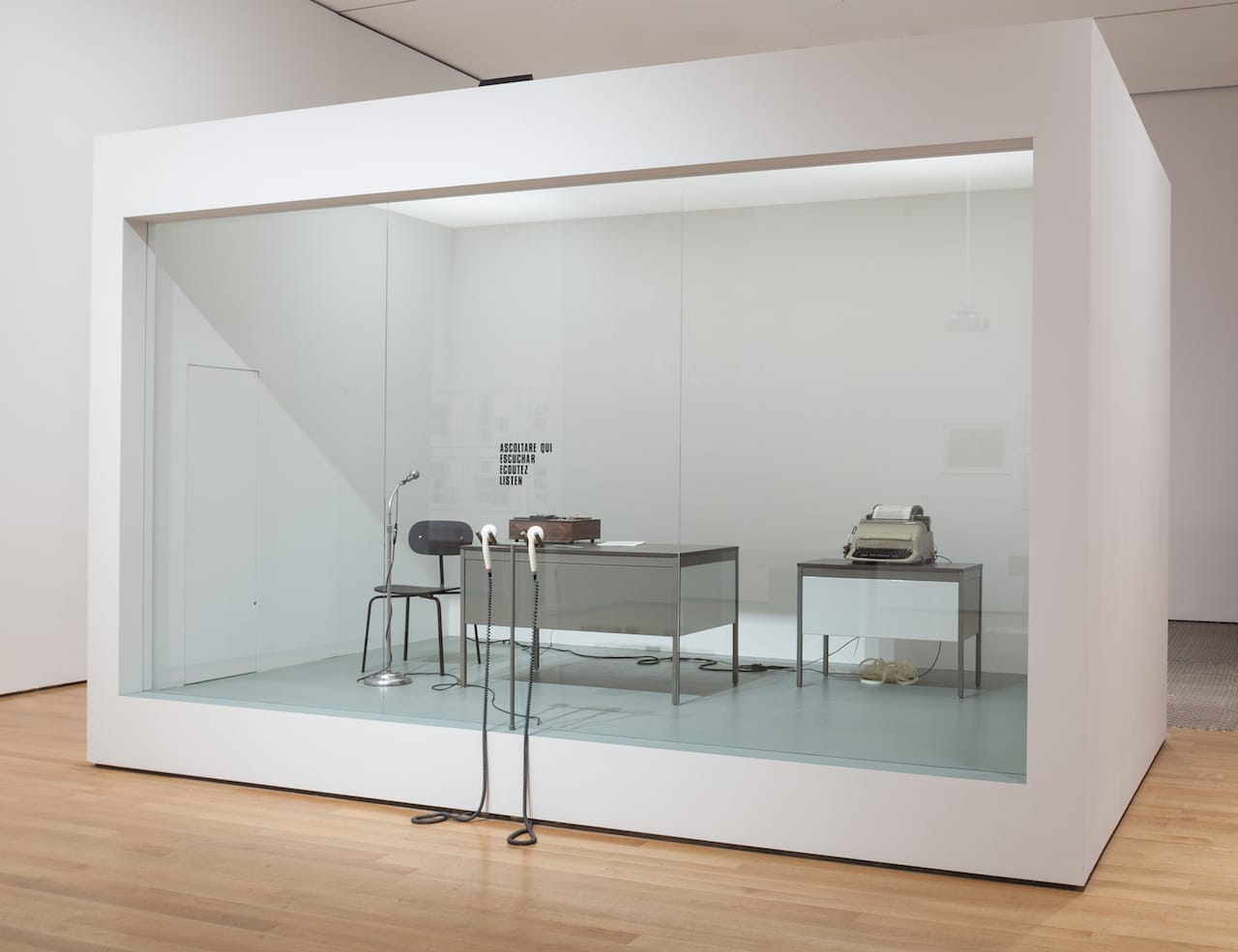 David Lamelas, "Office of Information about the Vietnam War at Three Levels: The Visual Image, Text and Audio" (1968/2015), office furniture, telex, tape recorder, microphone, telephone receivers, text, Plexiglas partition, and performance