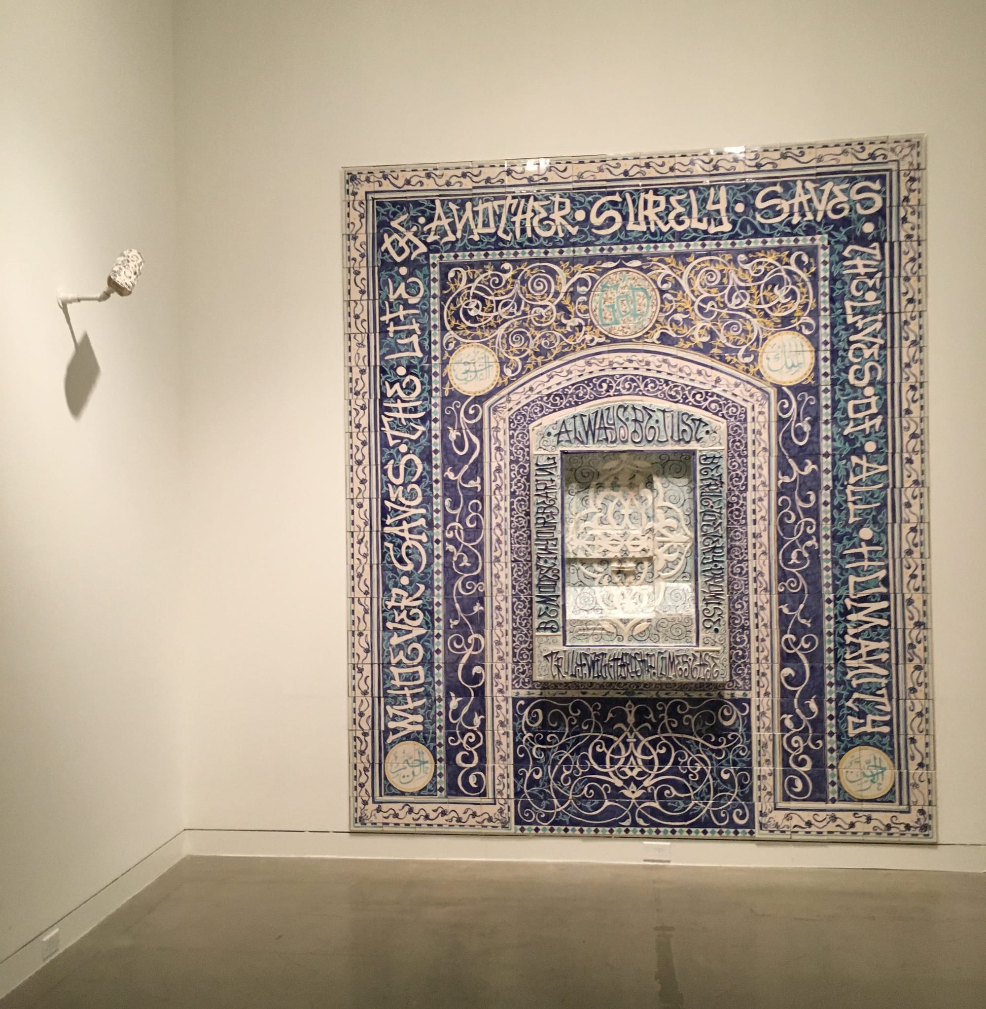 Installation view of Elyse Pignolet and Sandow Birk's "Untitled (Whoever saves the life of another surely saves the lives of all humanity)" (2015) and "American Mihrab (White)" (2009)
