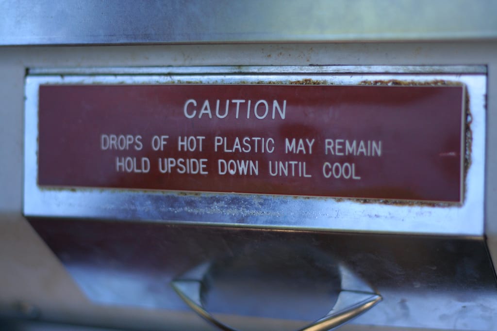 Caution sign on a Mold-A-Rama machine at the Oklahoma City Zoo in 2010 (photo by Kelly Teague/Flickr)