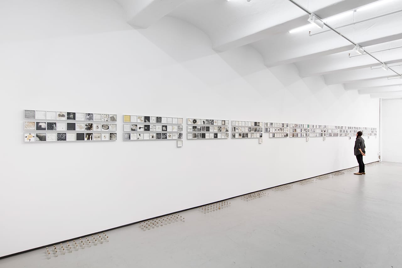 Vibha Galhotra, "365 Days" (2015), 365 drawings made of ink, photocopy, collage and sediment on paper, and 365 glass bottles, 4 1/2 x 4 1/2 x 1 3/8 in (each framed drawing), 2 3/4 x 1 3/4 diameter (each glass bottle), overall installation dimensions variable (click to enlarge)