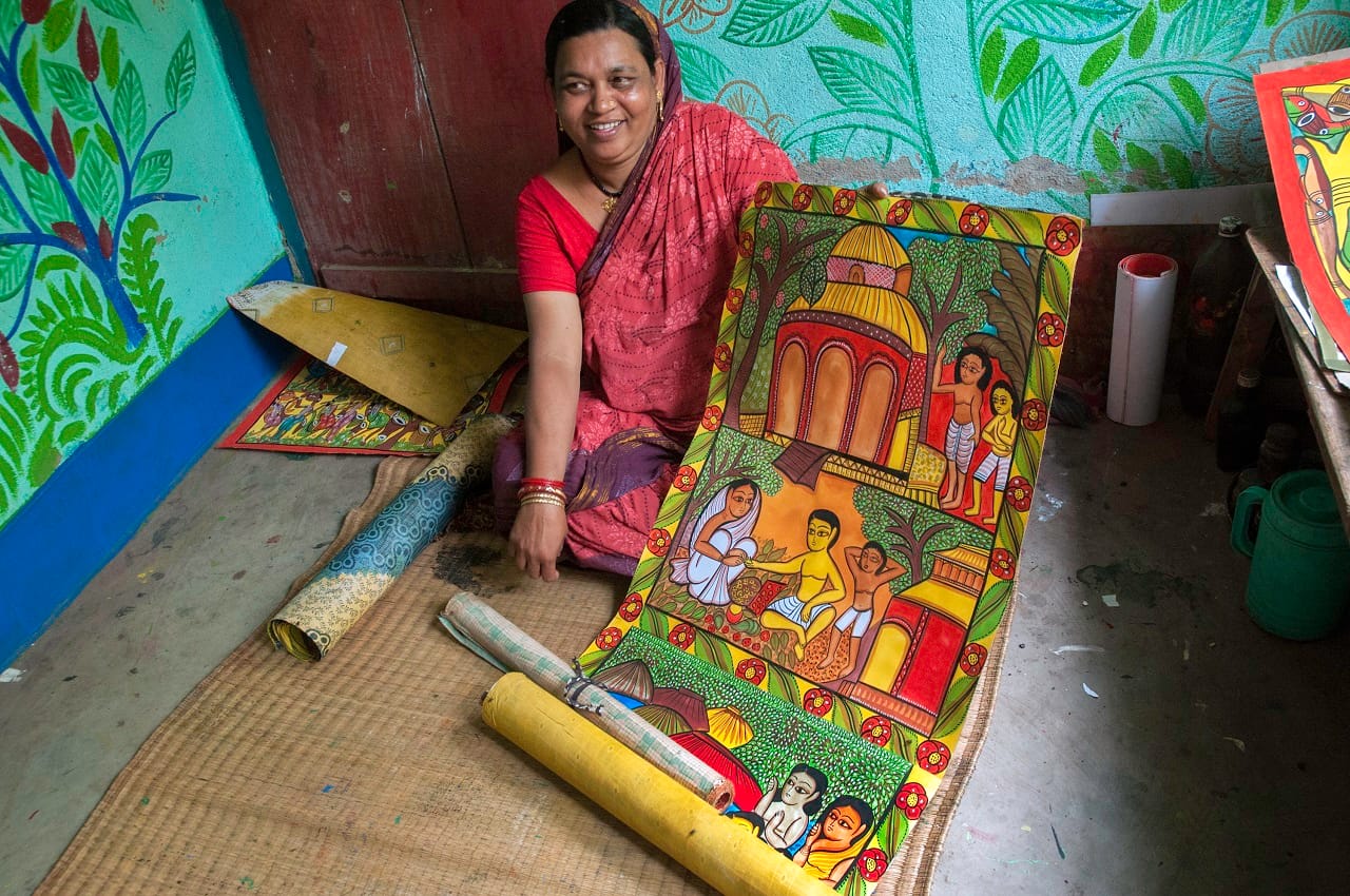 Swarna Chitrakar, with one of her hand-painted scrolls