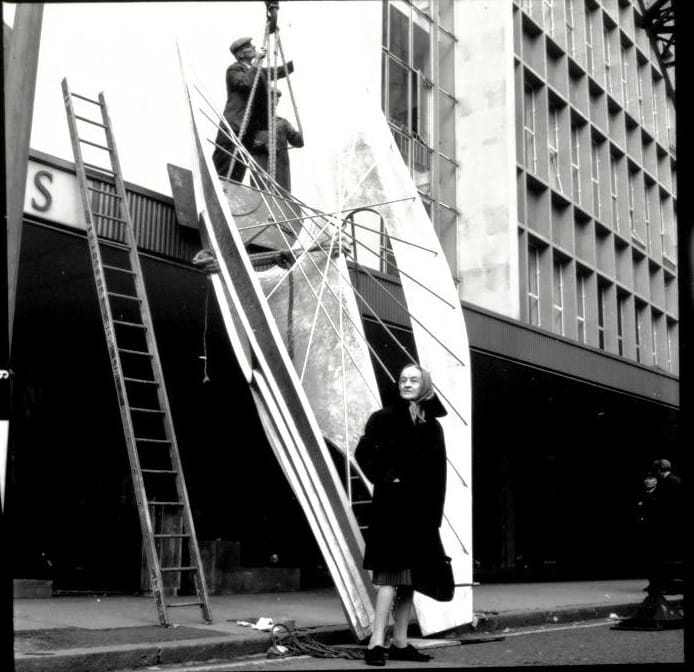 Private Public ArtInstallation of Barbara Hepworth’s Winged Figure, 1961-2, Holles Street, London, with the artist looking on. The private sector was also pivotal in the creation of important works of art. Hepworth’s Winged Figure which she created for the John Lewis Partnership is a key example of sculpture commissioned for commercial premises. Copyright John Lewis Partnership Archives