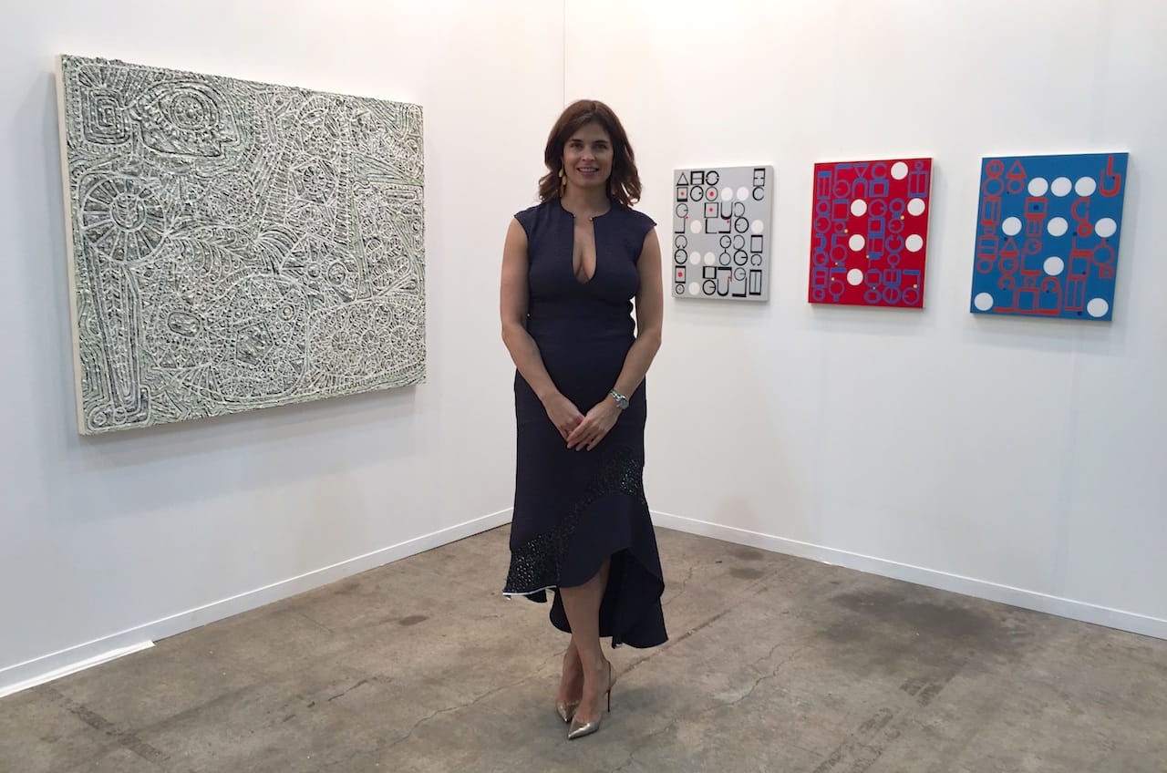 Wendi Norris in front of work by Helen Rebekah Garber
