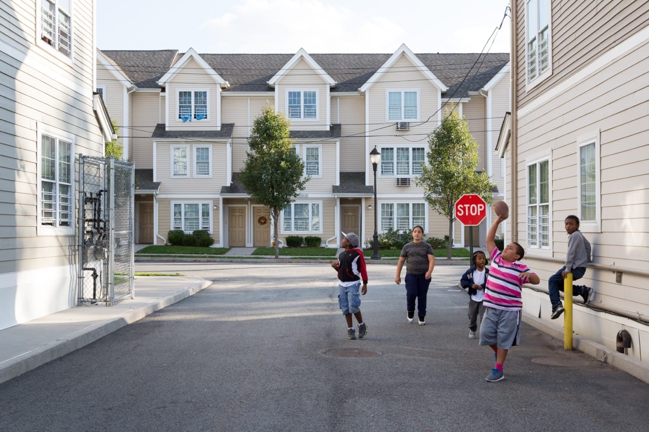 Markham Gardens Kids Walking Through Buildings. Photo by David Schalliol