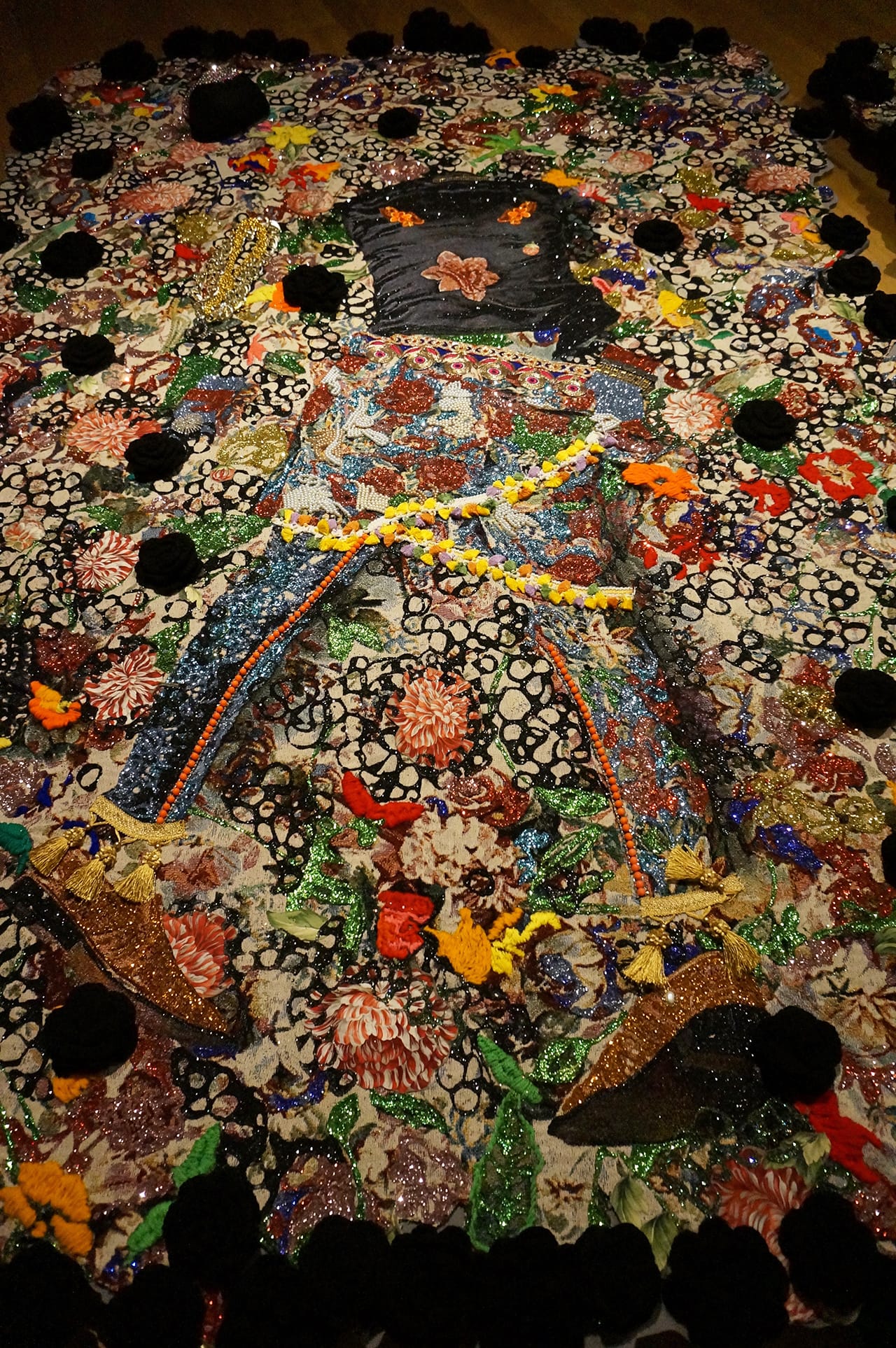 Detail of Ebony G. Patterson, “wilted rosez” (2014), mixed-media jacquard tapestry, with embroidery, glitter, caftan, costume jewelry, glass, eighty black crocheted flowers, embellishments