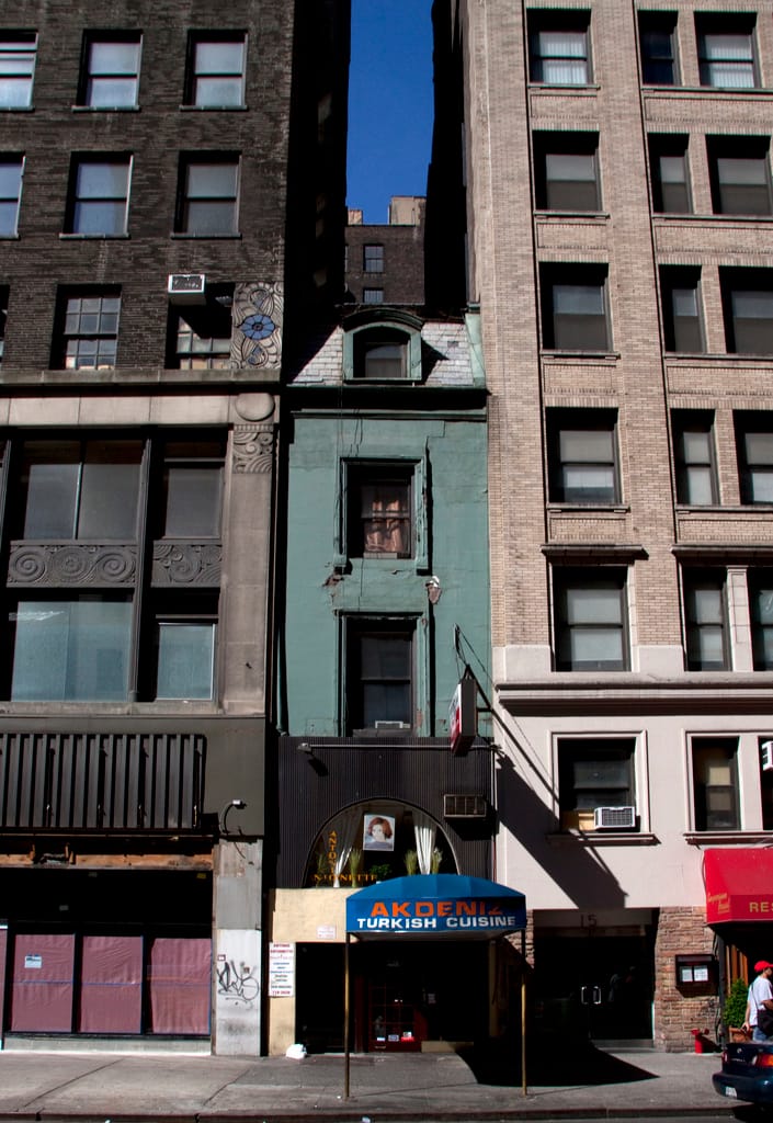 An old building caught between two newer structures in Manhattan (photo by Tony Hisgett/Flickr)