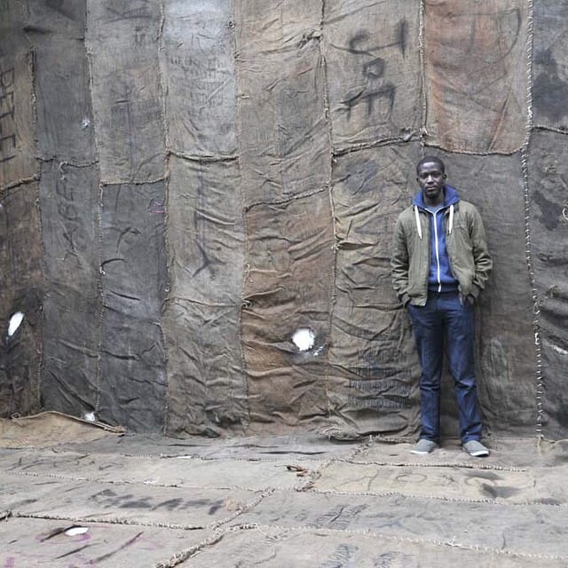 Ibrahim Mahama in his installation "Civil Occupation" at Ellis King in 2014 (photo by @jonathanellisking/Instagram)