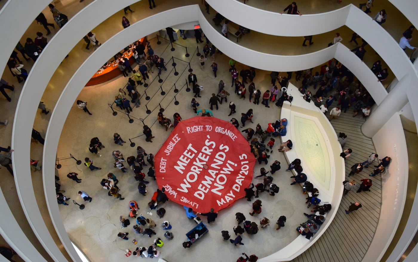 On May Day 2015, members of the Gulf Ultra Luxury Faction unveiled a large parachute in the Guggenheim Museum rotunda with the words “Meet Workers Demands Now!” (photo by Benjamin Sutton/Hyperallergic)